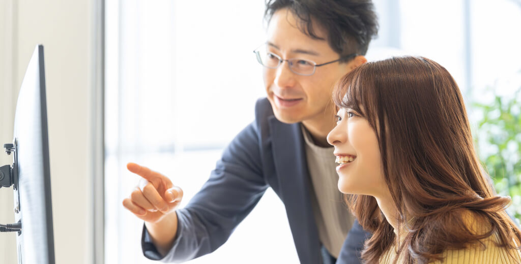 パソコンを教える男性と女性